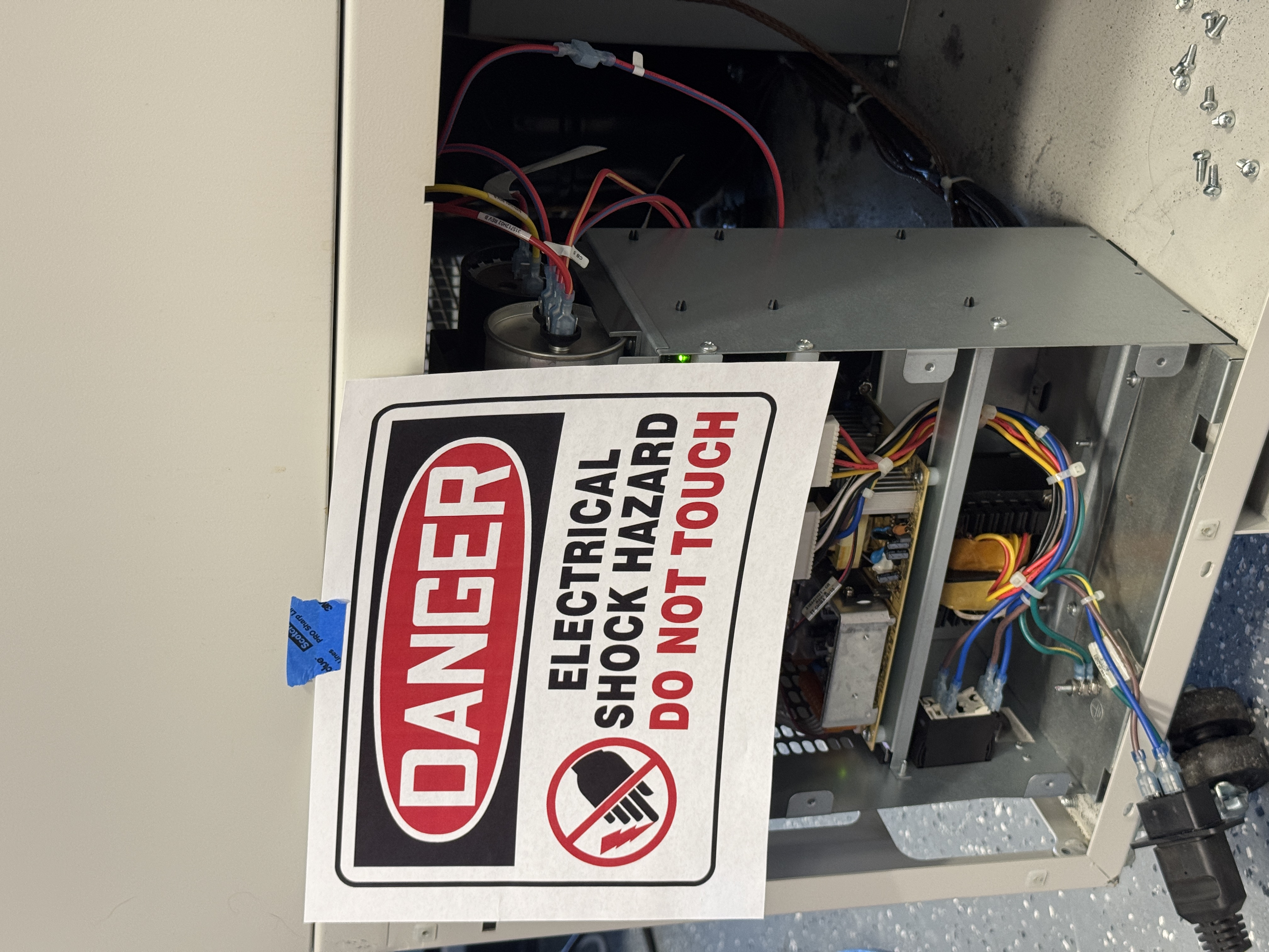 Freezer power supply opened up, with a coord haphazardly dangling from it