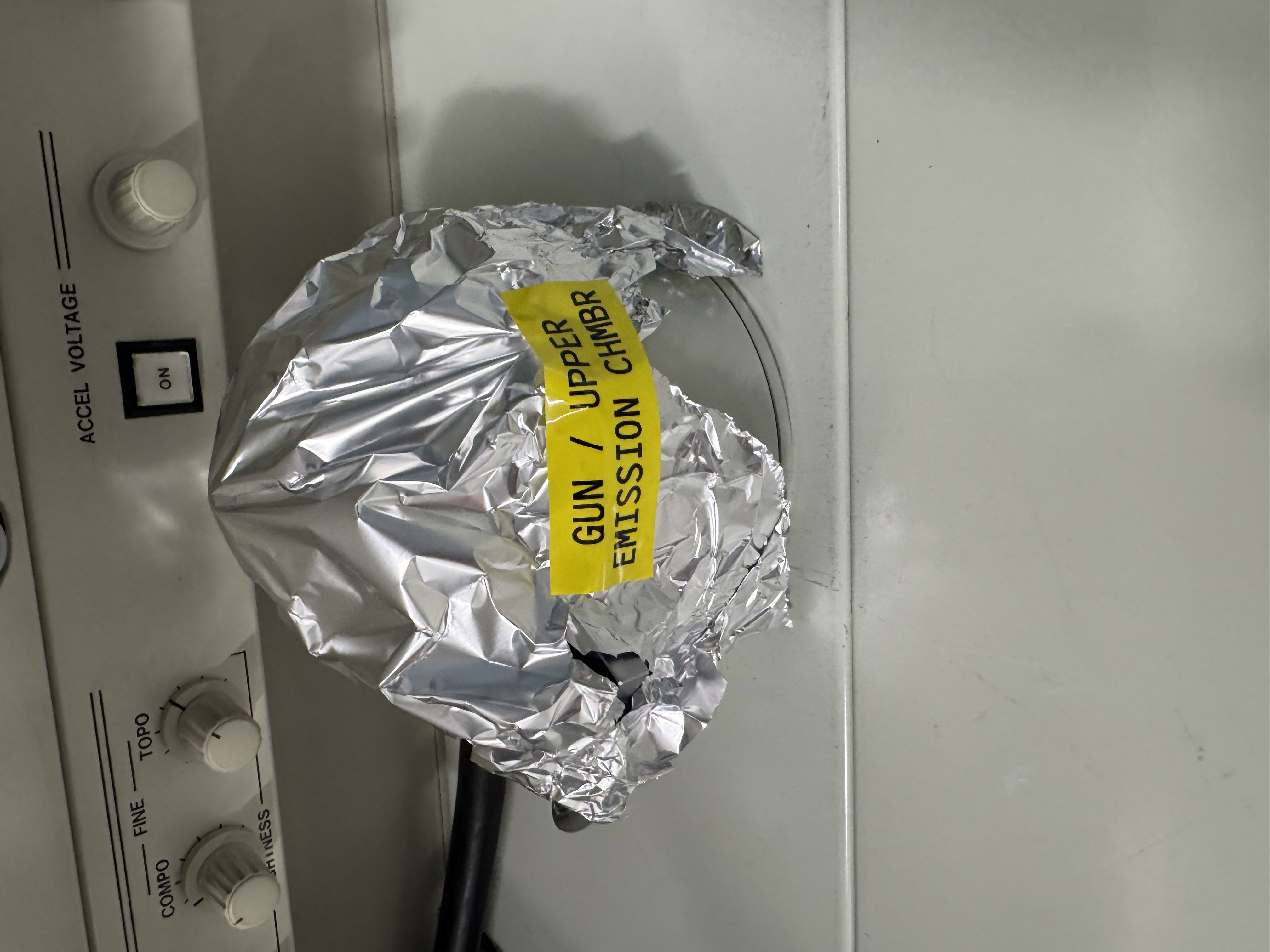 The electron gun sitting on the bench covered in tinfoil