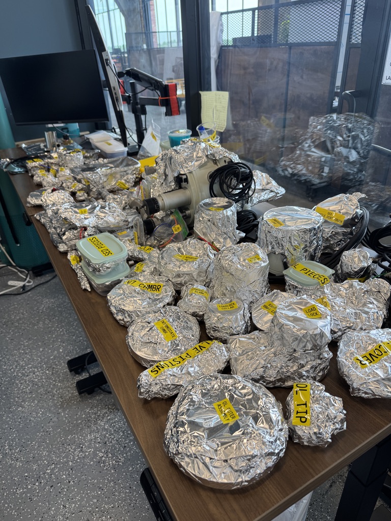 An array of parts spanning 2 tables wrapped in tinfoil