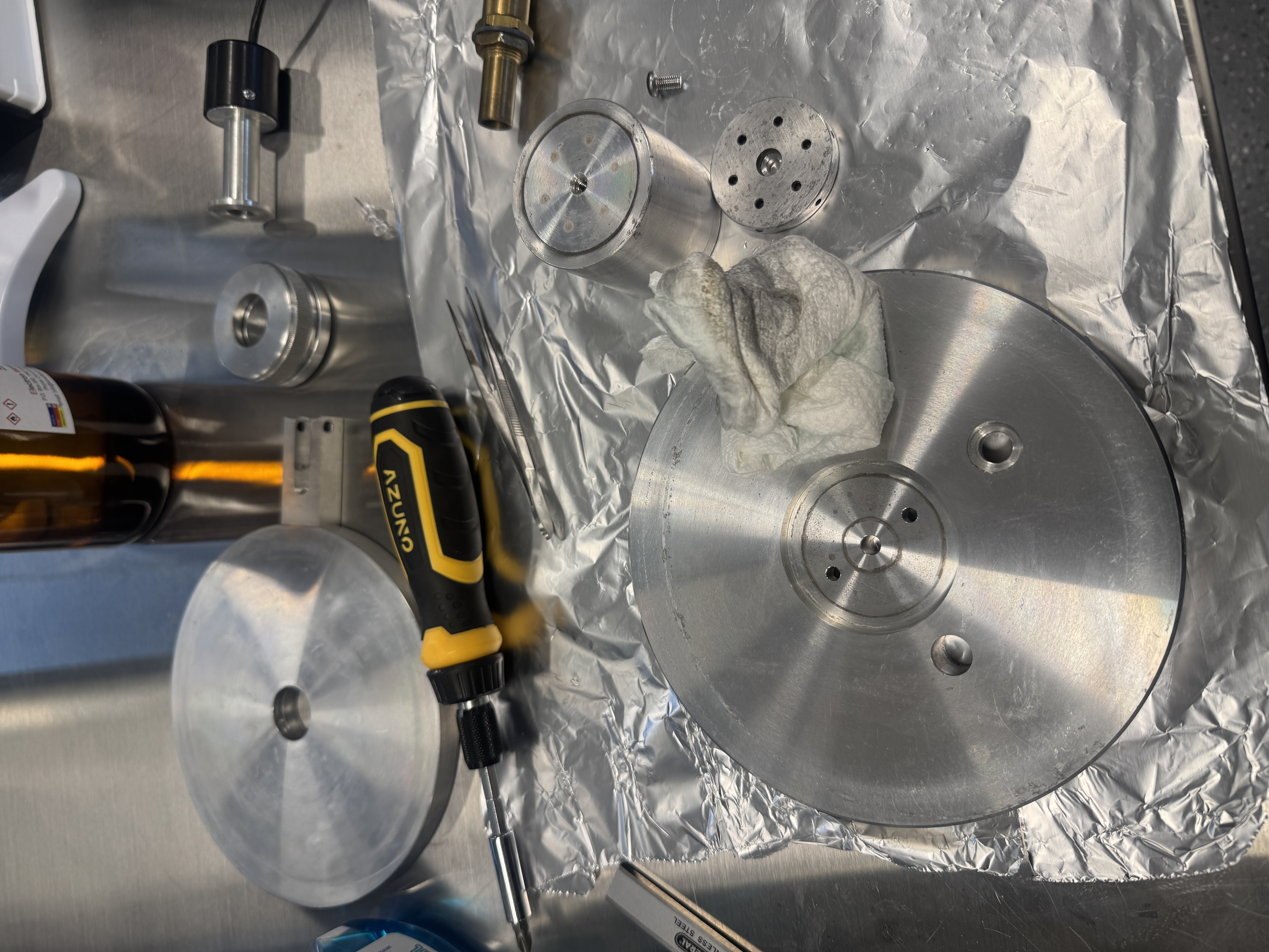 A cloth shown next to metallic components with residue, deep in the process of cleaning