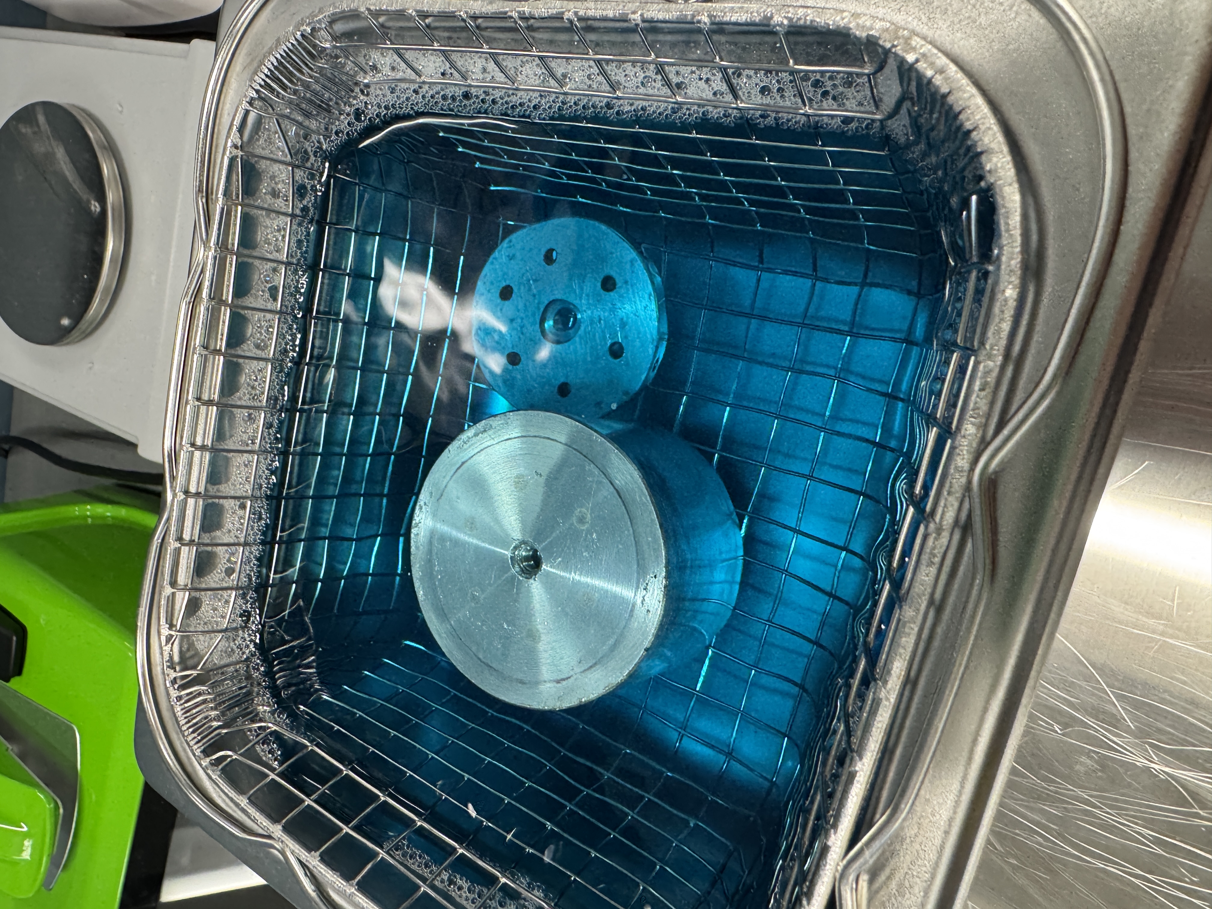 Pieces of the sputter coater inside the ultrasonic cleaner